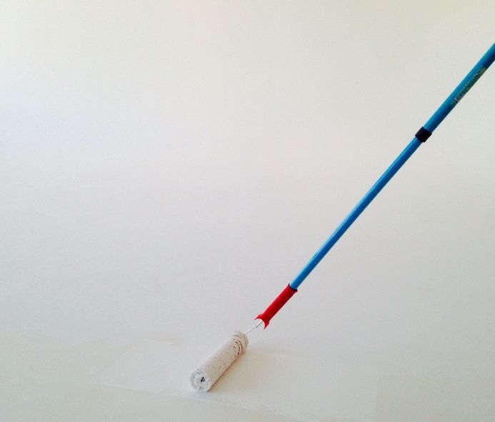 Painter roll with white color against white wall to represent problem solving in software engineering.