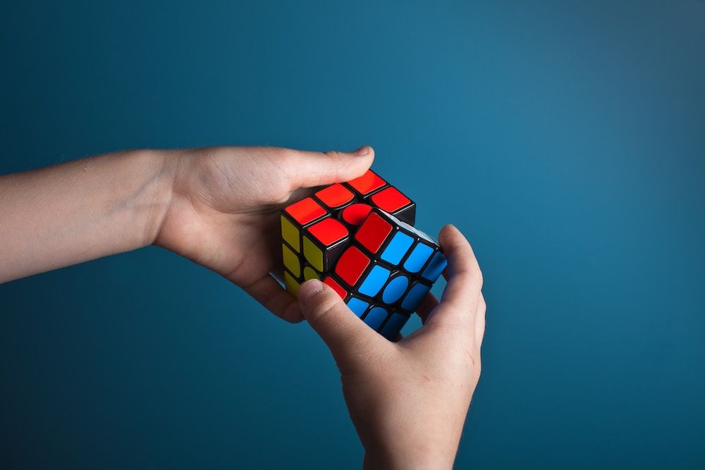 Person solving a rubiks cube representing problem solving